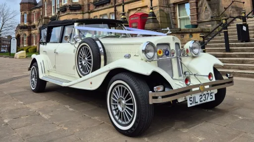 Cream Beauford convertible with wedding ribbons, roof folded down and chrome features visible.