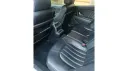 Rear interior of Maserati Quattroporte showing black leather seats, centre console and modern luxury cabin finish.