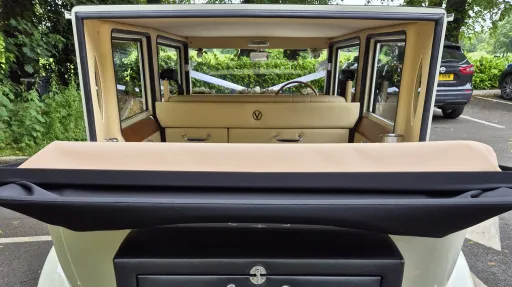 Rear view inside Imperial wedding car with roof open, showing cream leather seating and open-air cabin.