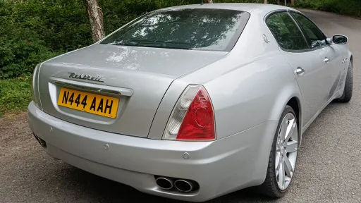 Rear view of silver Maserati Quattroporte showing distinctive tail lights, chrome exhausts and elegant saloon styling.