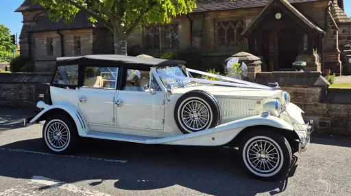 Full side view of cream Beauford convertible with roof down and long body styling.