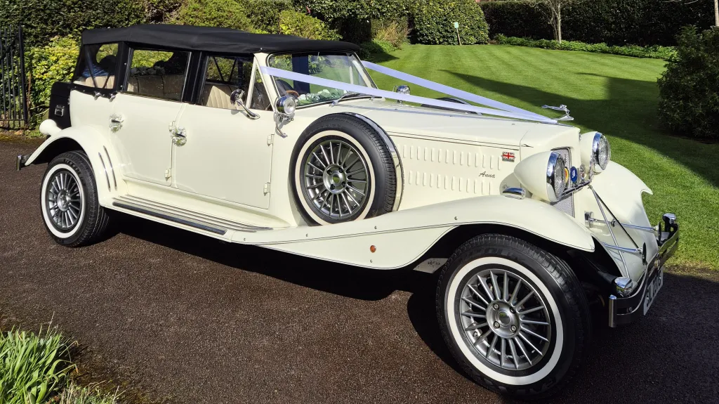 Right side view of cream Beauford wedding car with side mounted spare wheel and chrome detailing.