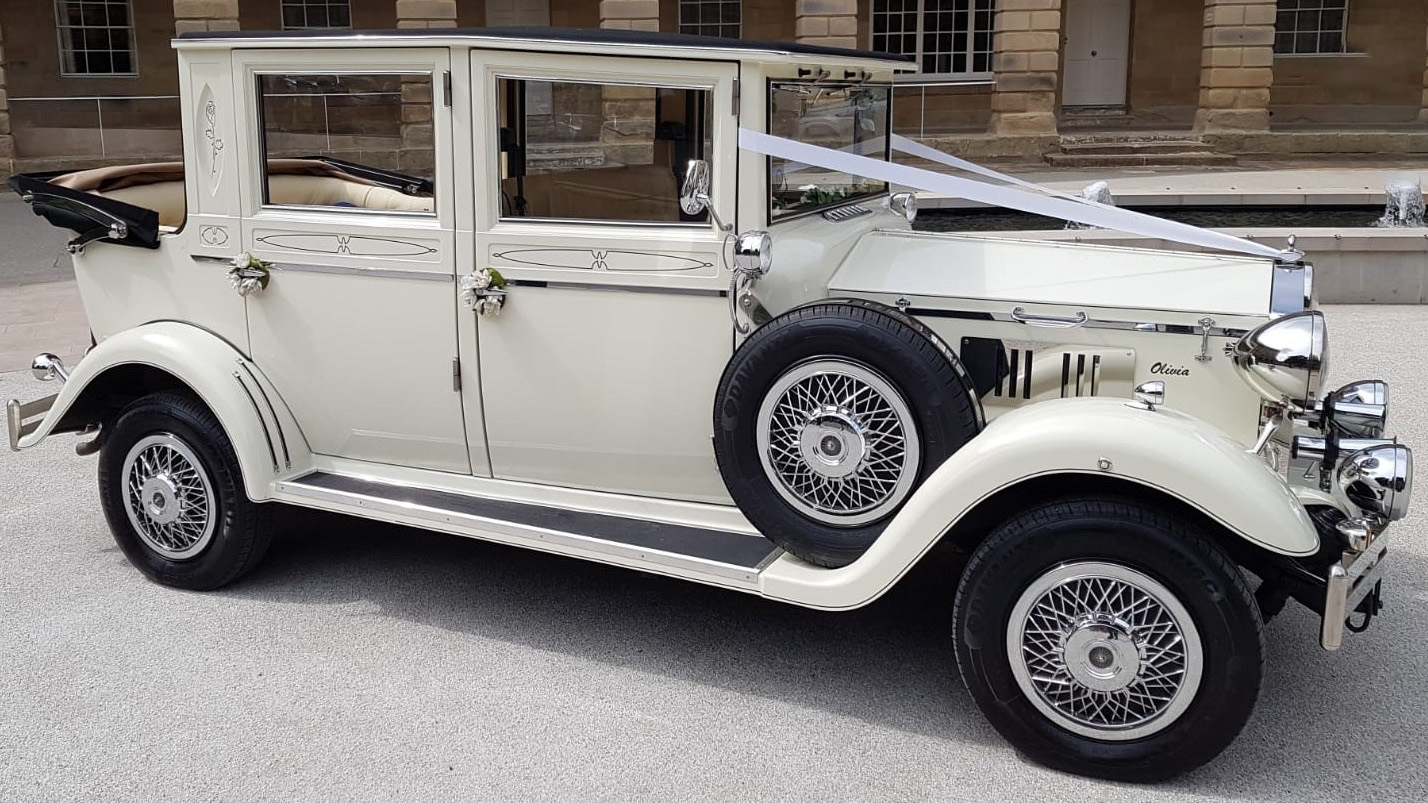 Cream 1930s style Imperial wedding car parked on a road in Warrington, Cheshire, with chrome grille and classic styling.