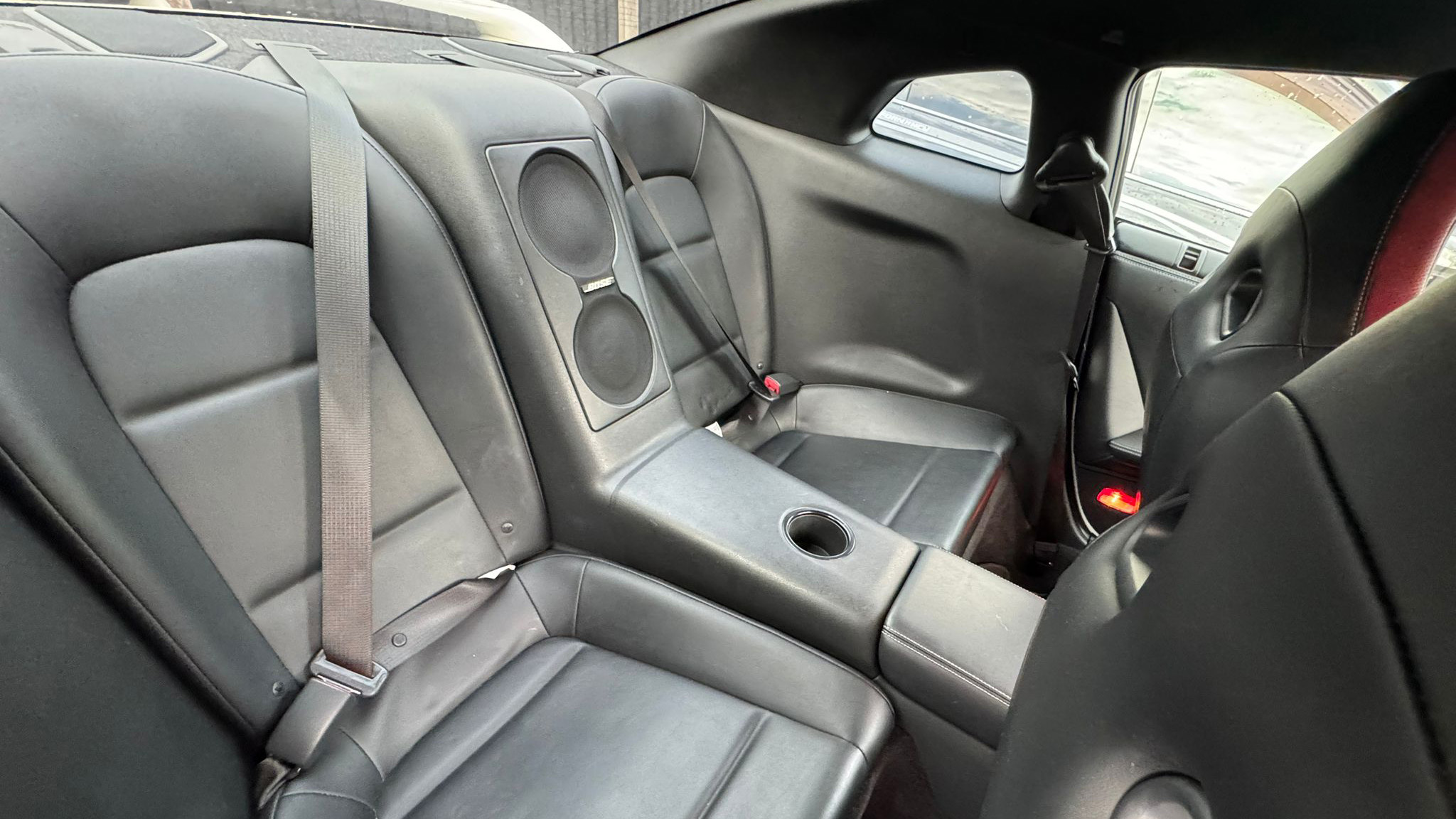 Rear interior of Nissan GTR R35 showing compact bucket-style seating with centre console, dark upholstery and sporty finish.