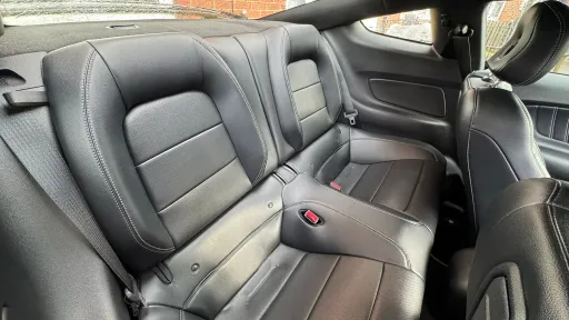 Rear interior of Ford Mustang GT showing two rear seats in black leather, compact cabin space.