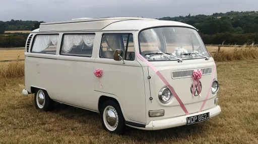 front right side view campervan parked in a field dressed with wedding ribbons and bows
