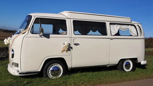 Old English White campervan side profile, doors closed, subtle wedding decoration, parked at venue