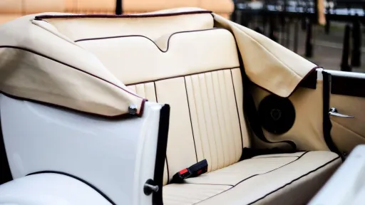 Cream leather forward-facing rear bench seat inside Beauford Landaulette limousine with spacious legroom