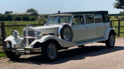 Left side view Beauford Landaulette limousine with black convertible rear roof and white body