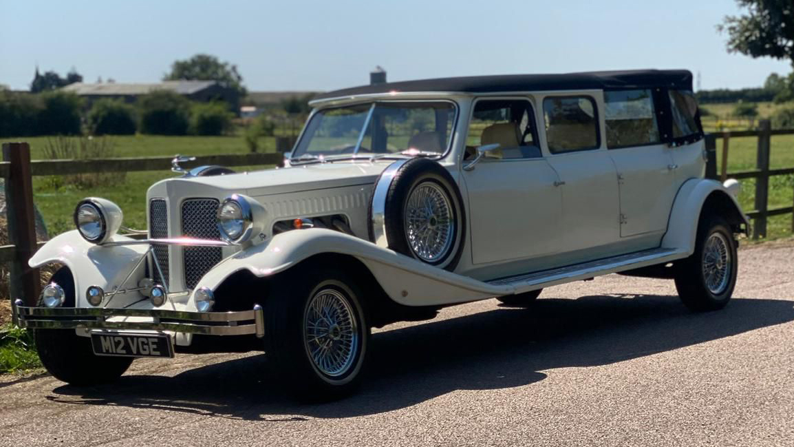 Left side view Beauford Landaulette limousine with black convertible rear roof and white body