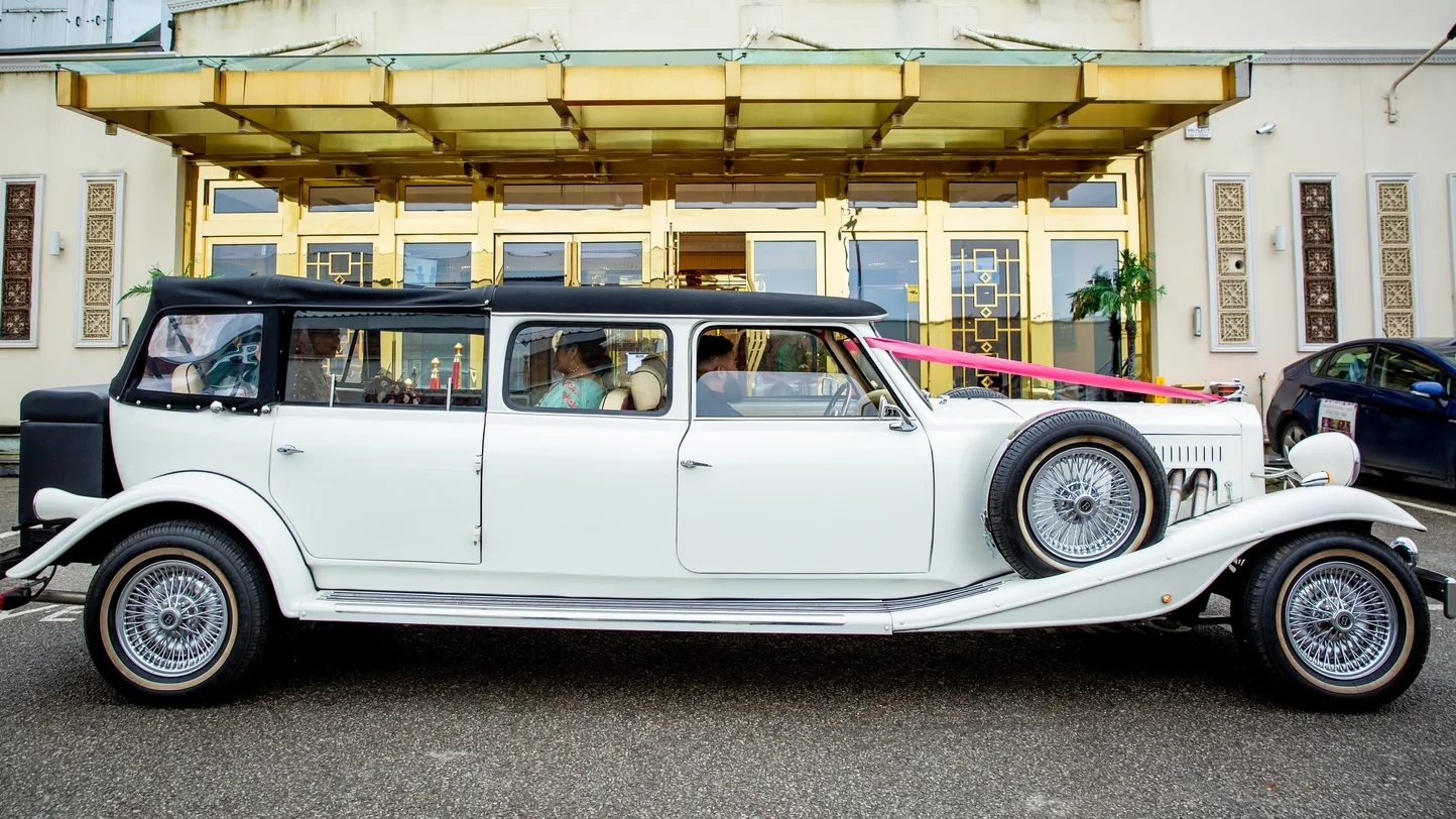 Right side view white Beauford Landaulette limousine with wedding ribbons and long vintage profile