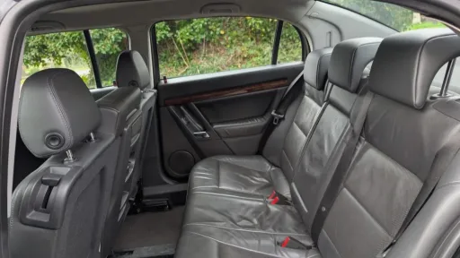 Middle row black leather seats inside stretched Vauxhall Vectra limousine
