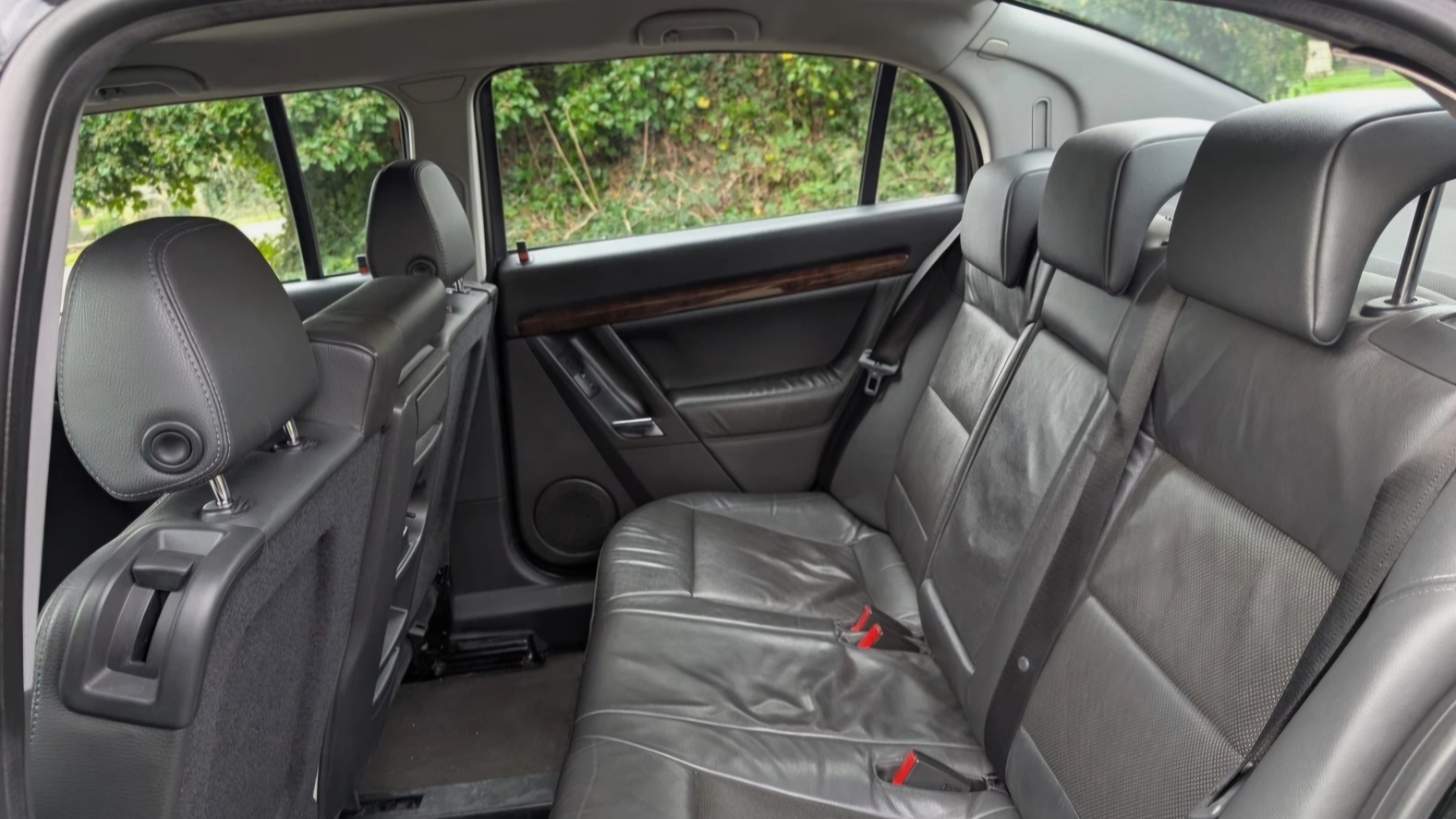 Middle row black leather seats inside stretched Vauxhall Vectra limousine