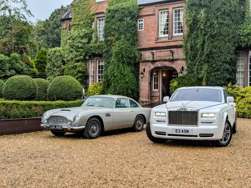 Iconic Astion Martin DB5 parked next to a modern White Rolls-Royce Phantom outside a local wedding venue in Manchester