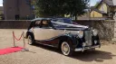 Austin Sheerline wedding car in black and Old English White parked beside red carpet at Kent wedding venue