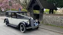 Black and ivory Austin 18 York vintage wedding car parked outside countryside church in Maidstone, Kent.