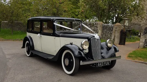 1935 Austin 18 York wedding car in black and ivory parked outside historic venue in Kent with classic whitewall tyres.