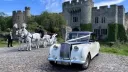 Austin Princess limousine wedding car outside Kent castle venue with horse and carriage in the background.