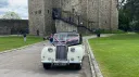 Front view of black and ivory Austin Princess limousine with pink wedding ribbons at countryside venue in Kent.