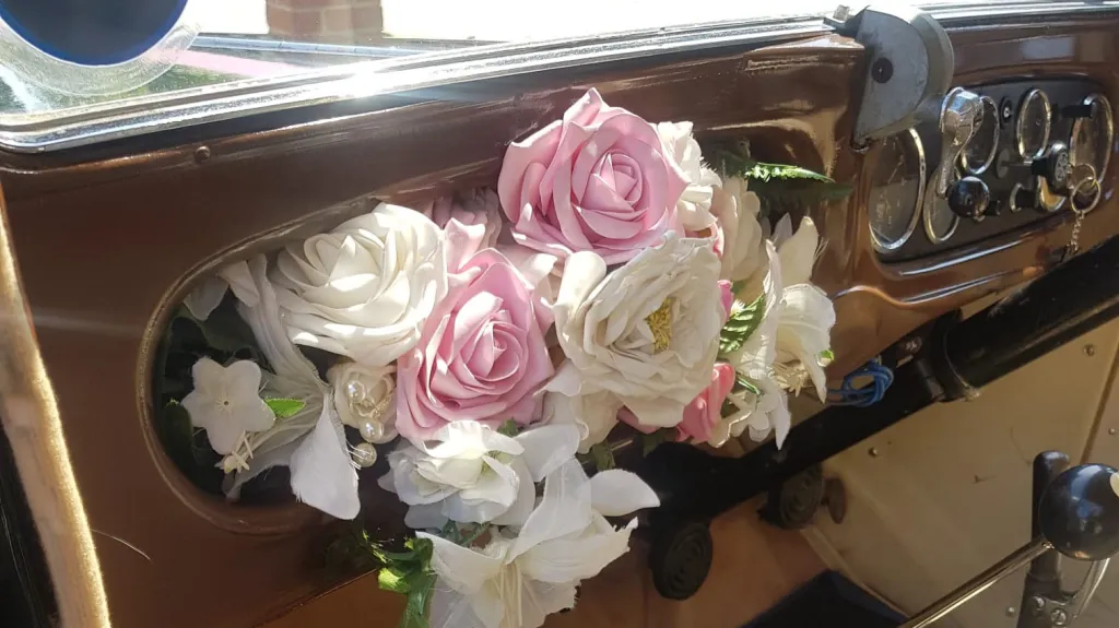 Vintage Austin 18 York wooden dashboard decorated with pink and white wedding flowers inside classic wedding car.