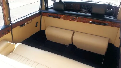 Spacious cream leather rear cabin inside classic Daimler limousine wedding car.