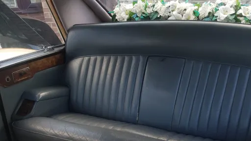 Rear grey leather bench seating inside classic Daimler DS420 limousine wedding car.