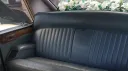 Rear grey leather bench seating inside classic Daimler DS420 limousine wedding car.