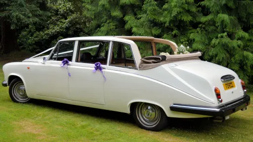 Rear left angle view of Daimler limousine landaulette with open roof and cream interior.