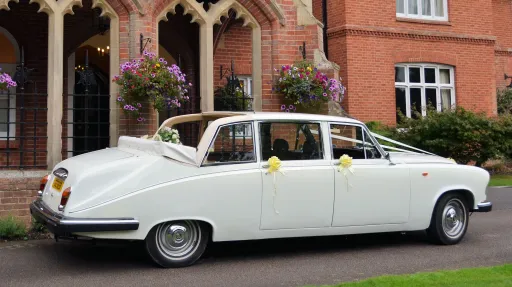 Right side view of white Daimler limousine wedding car with landaulette roof folded open.