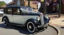 Front side view of black and ivory Austin 18 York wedding car with chrome details and whitewall tyres.