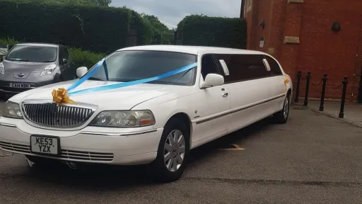 White Lincoln Town Car stretched limousine wedding car parked beside hotel entrance in Kent.