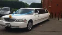 White Lincoln Town Car stretched limousine wedding car parked beside hotel entrance in Kent.