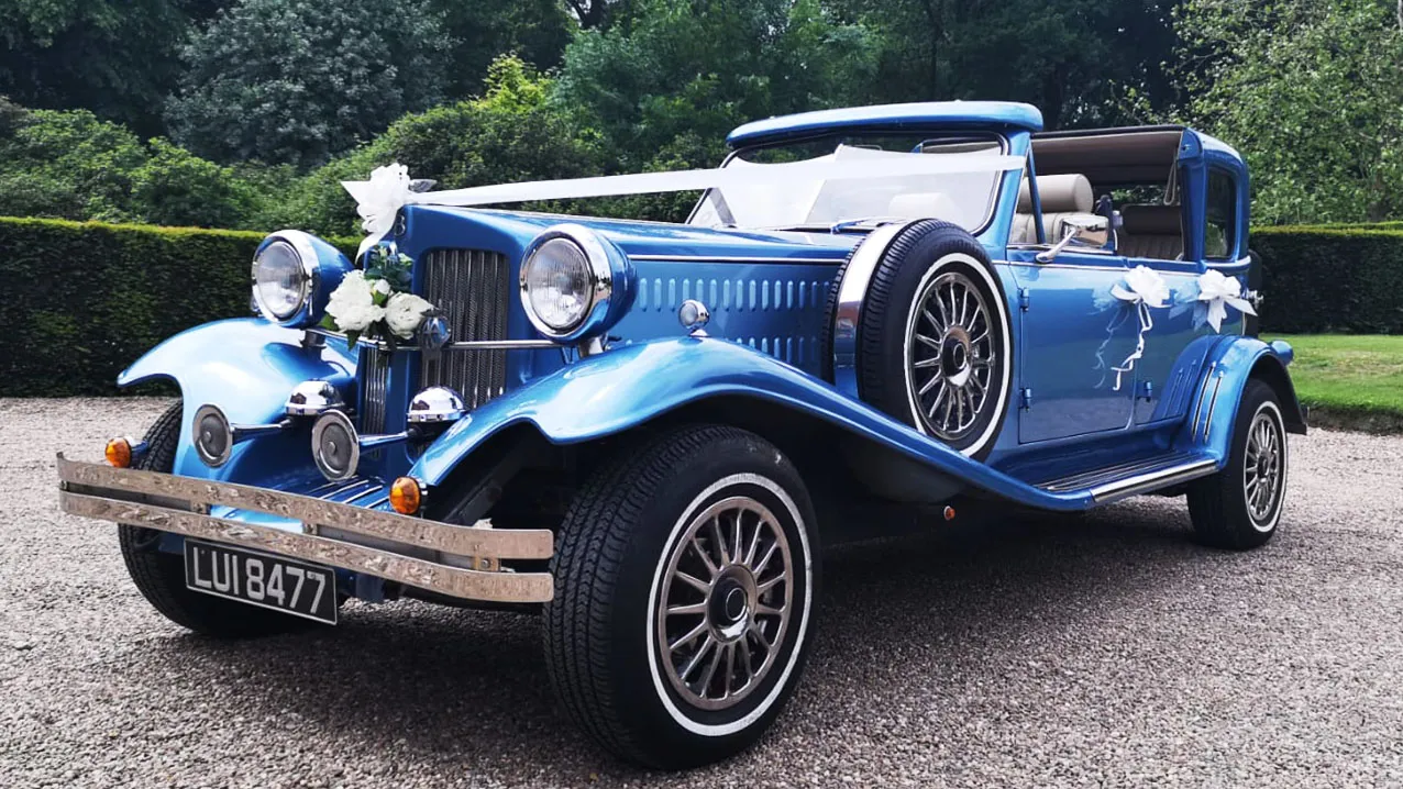 Classic blue Beauford wedding car with vintage styling and chrome features parked at a wedding venue in Kent.