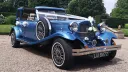 Blue vintage Beauford wedding car decorated with wedding ribbons and bows, photographed outside a countryside wedding venue.