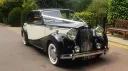 Austin Sheerline wedding hire car with white ribbons parked outside countryside venue in Kent.