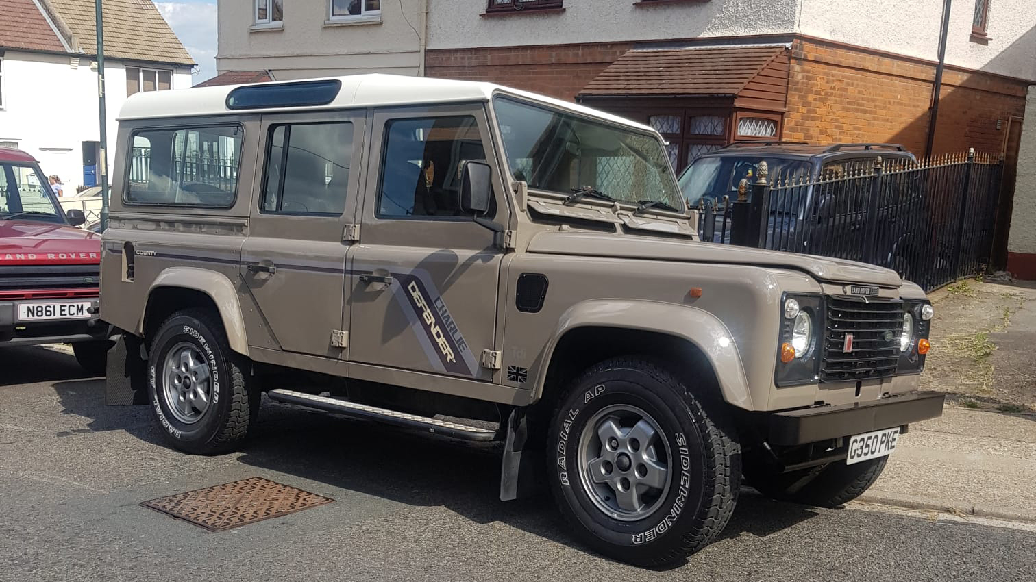 Beige Land Rover Defender wedding car with cream roof parked outside residential property in Kent.