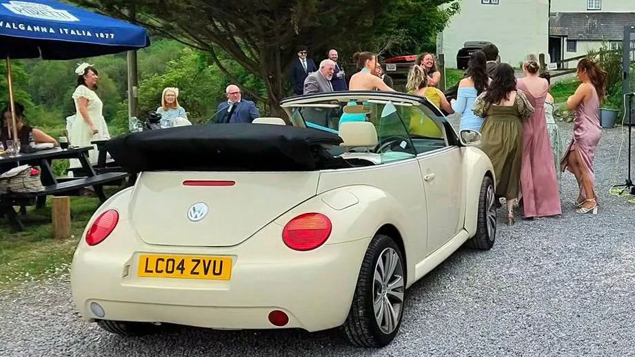 Ivory modern Beetle with wedding guests