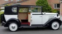 Right side view of Black and Ivory Regent car with rear passenger door open showing cream leather seats and burgundy carpet