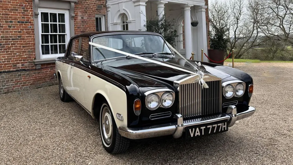 Black and ivory 1970 Rolls-Royce Silver Shadow Mark 1 wedding car parked on a gravel driveway.
