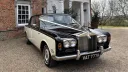 Black and ivory 1970 Rolls-Royce Silver Shadow Mark 1 wedding car parked on a gravel driveway.