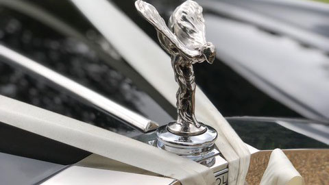 Rolls-Royce Flying Lady mascot on the chrome radiator grille of a classic Silver Shadow wedding car.