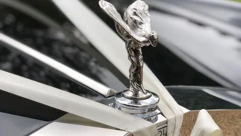 Rolls-Royce Flying Lady mascot on the chrome radiator grille of a classic Silver Shadow wedding car.