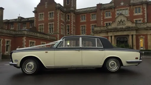Full left side view of a 1970 Rolls-Royce Silver Shadow Mark 1 wedding car outside a country house.