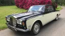 Ivory Rolls-Royce Silver Shadow Mark 1 with black roof and traditional wedding ribbons on the bonnet.