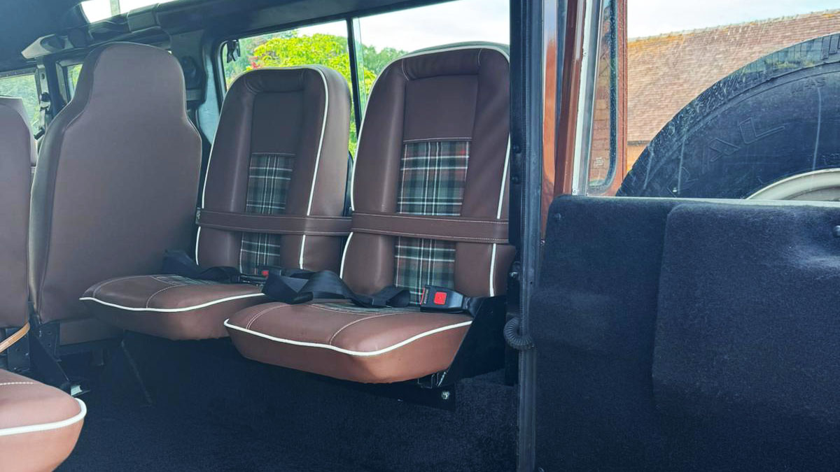 Rear passenger seating inside Land Rover Defender with individual seats and spacious cabin layout.