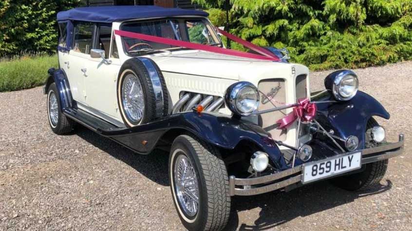 Ivory Beauford convertible wedding car decorated with burgundy wedding ribbons and chrome details.