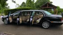 Black Jaguar stretch limousine with six doors open showing spacious cream leather interior seating.