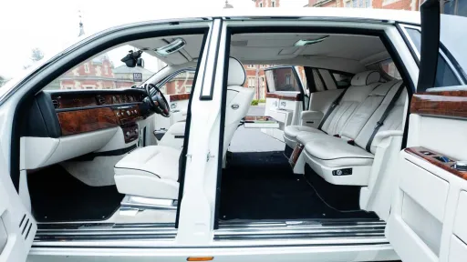 Rear passenger cabin inside Rolls-Royce Phantom Series II EWB showing extended legroom and white leather interior.