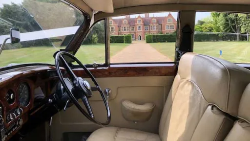 Front cream leather seating and dashboard inside classic silver Rolls-Royce Silver Cloud.