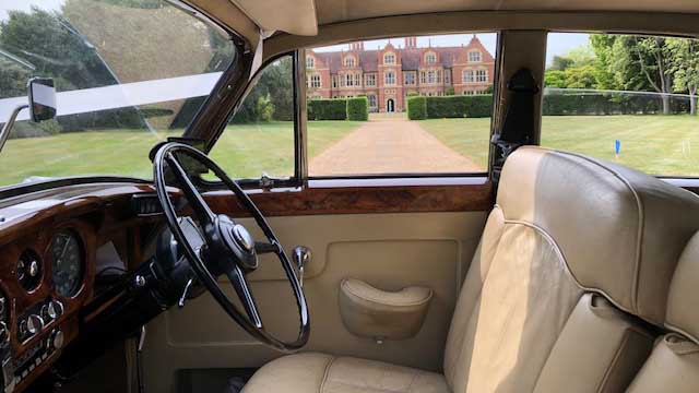 Front cream leather seating and dashboard inside classic silver Rolls-Royce Silver Cloud.